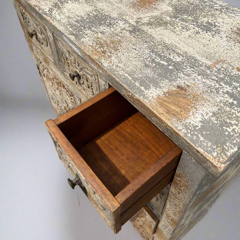 Vintage wooden dresser with a weathered surface and open drawer.