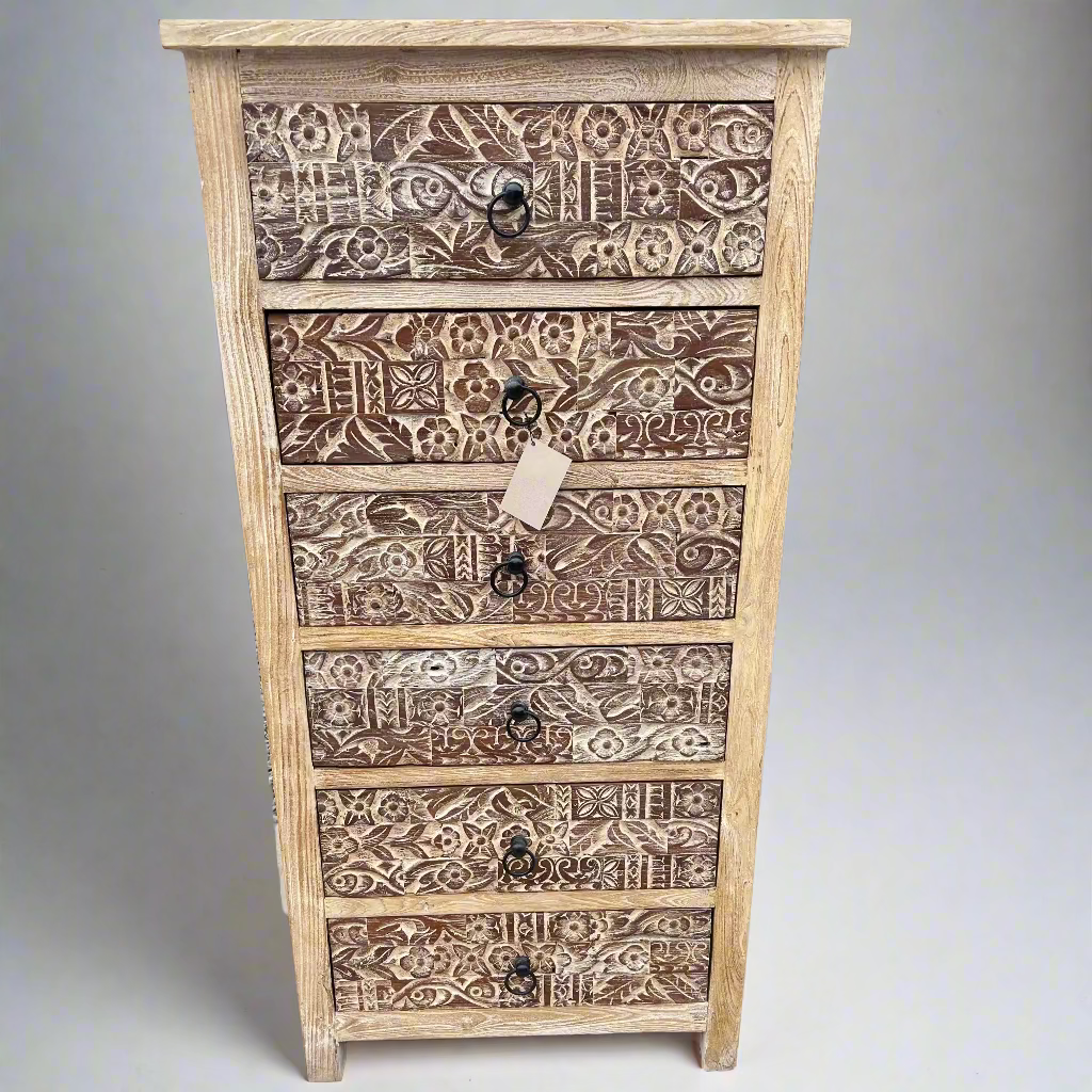 Wooden chest of drawers with intricate carvings.
