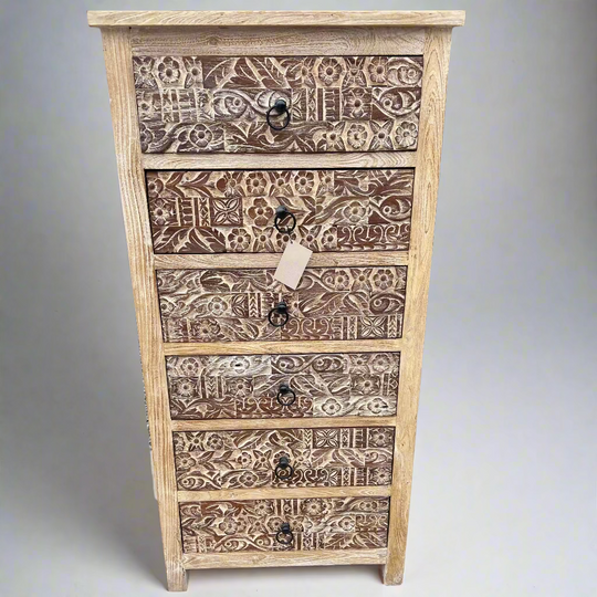 Wooden chest of drawers with intricate carvings.