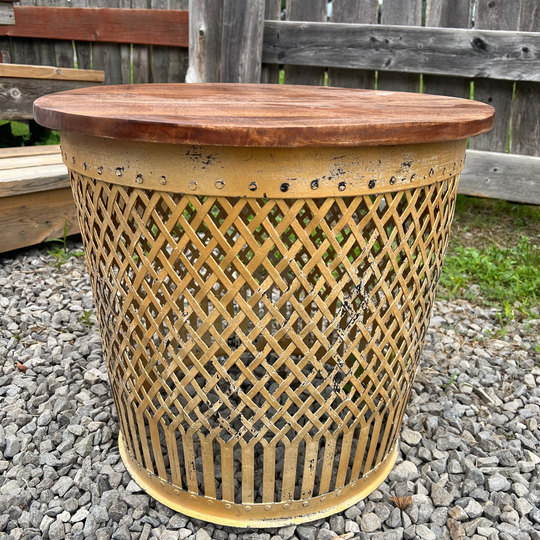 iron side table with wooden top on a gravel surface