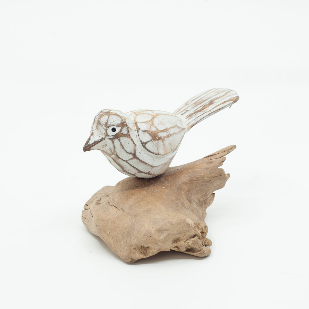 Small driftwood bird or on white background on wooden base.