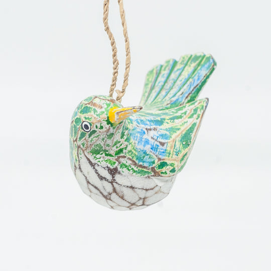 Small driftwood bird ornament on white background hanging from string.