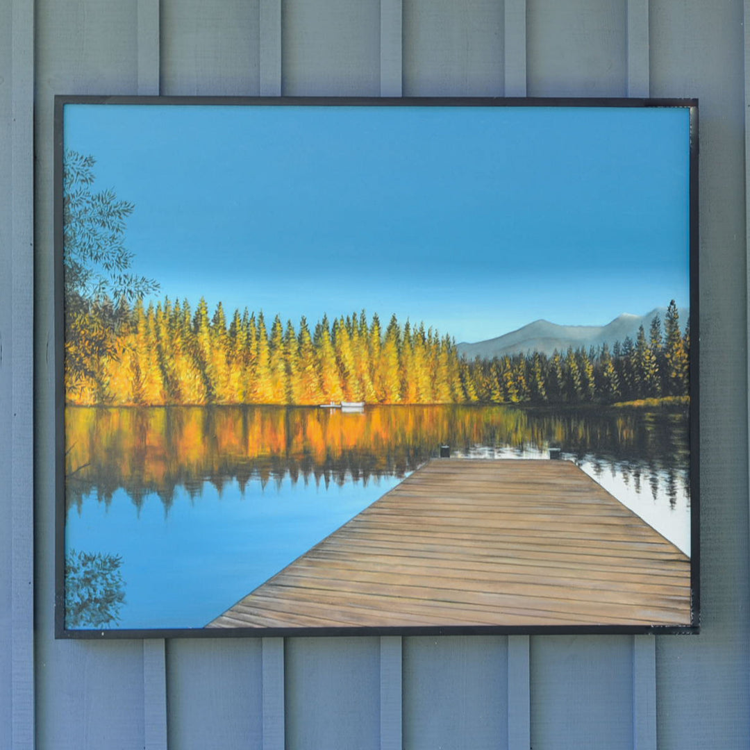 Dock looking out onto a calm lake and fall landscape