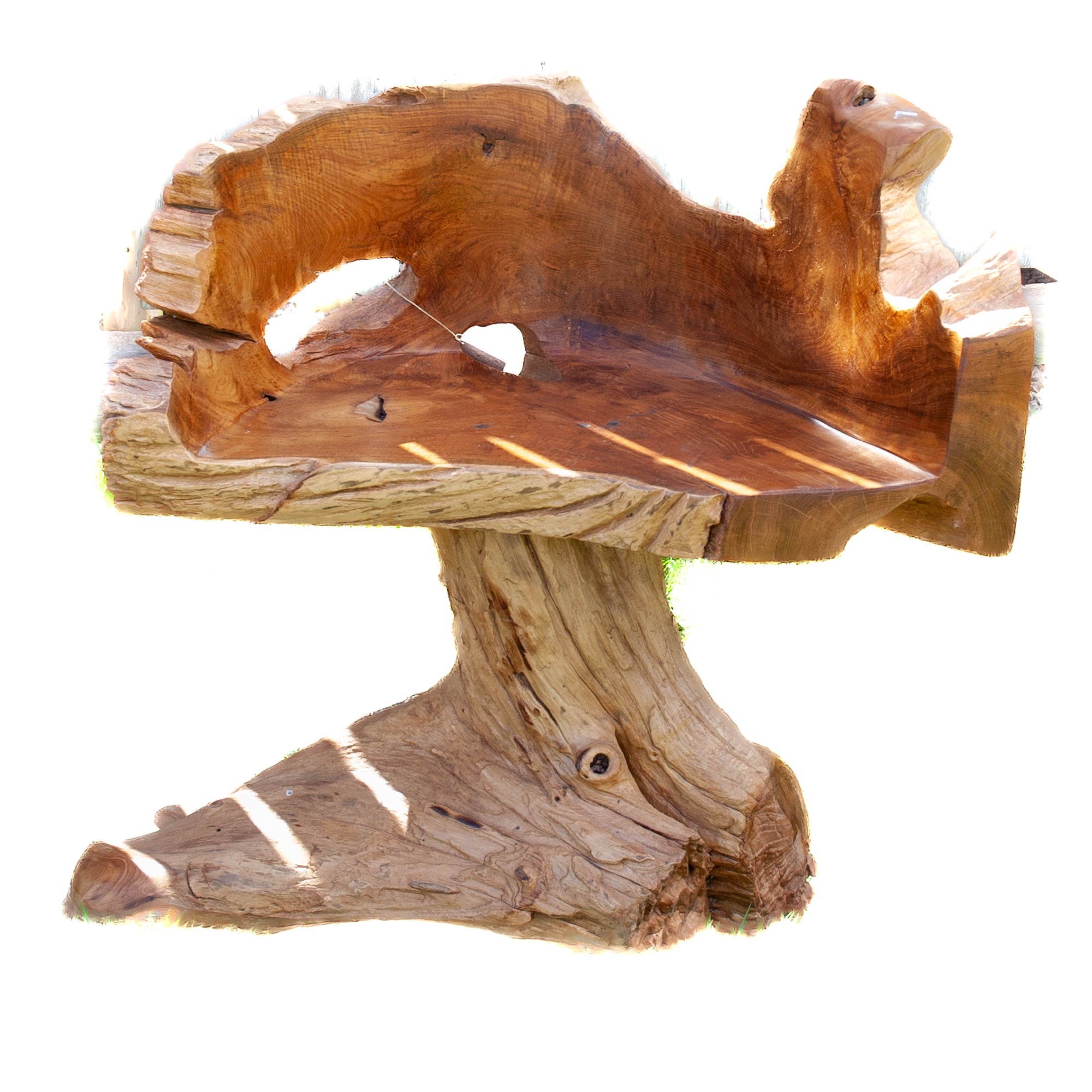 A natural teak wood chair, heavy looking, like it was carved from a tree stump