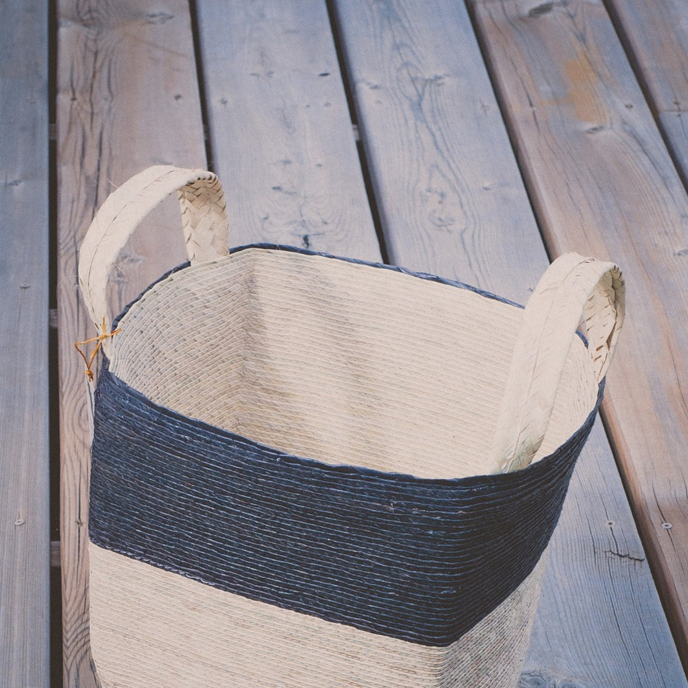 Natural woven baskets, three sizes on a wooden deck
