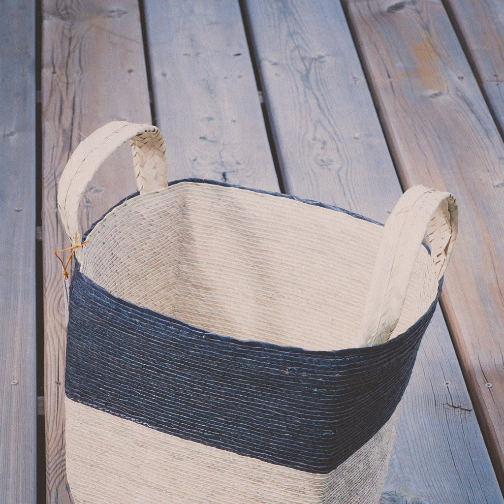 Natural woven baskets, three sizes on a wooden deck