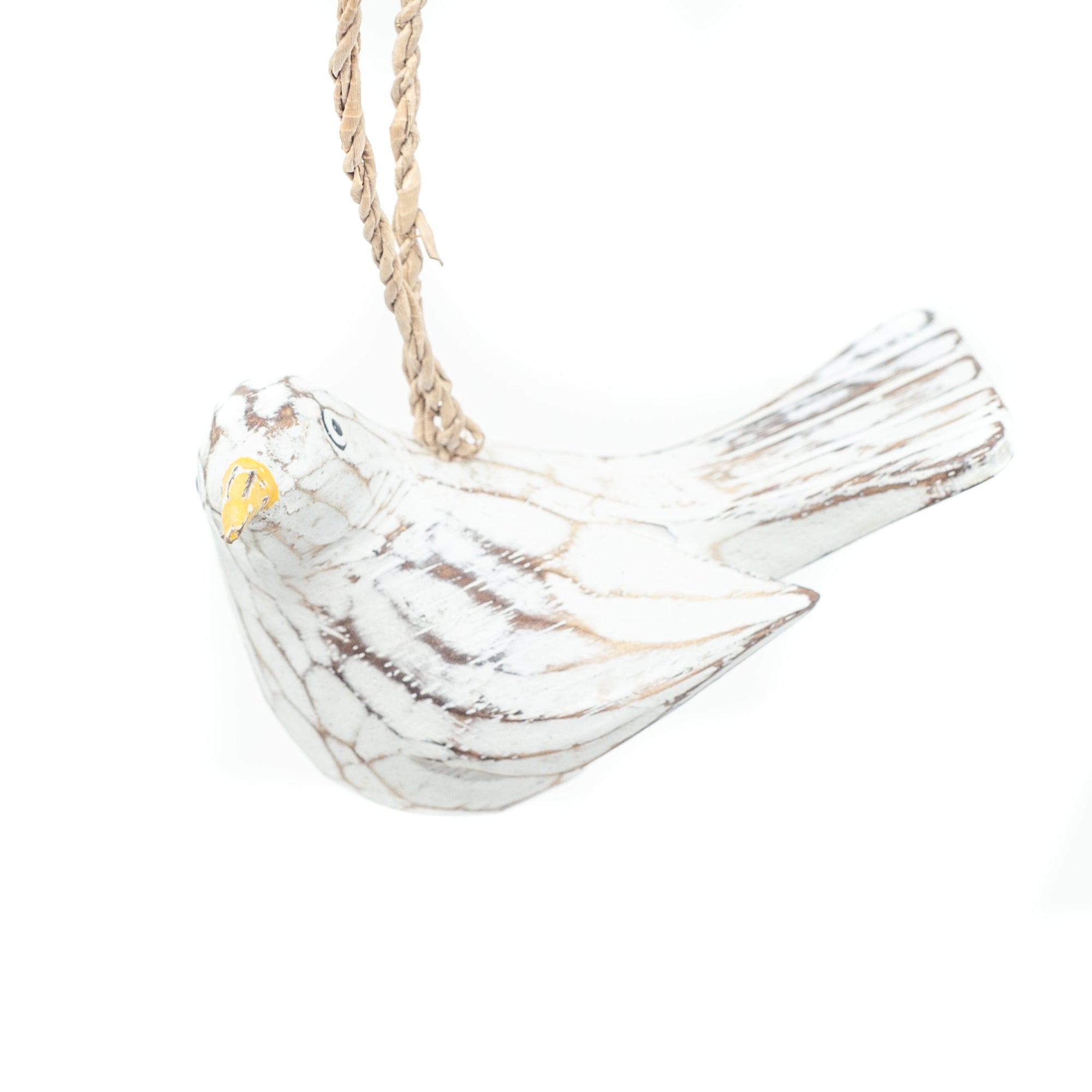 Small driftwood bird ornament on white background hanging from string. 