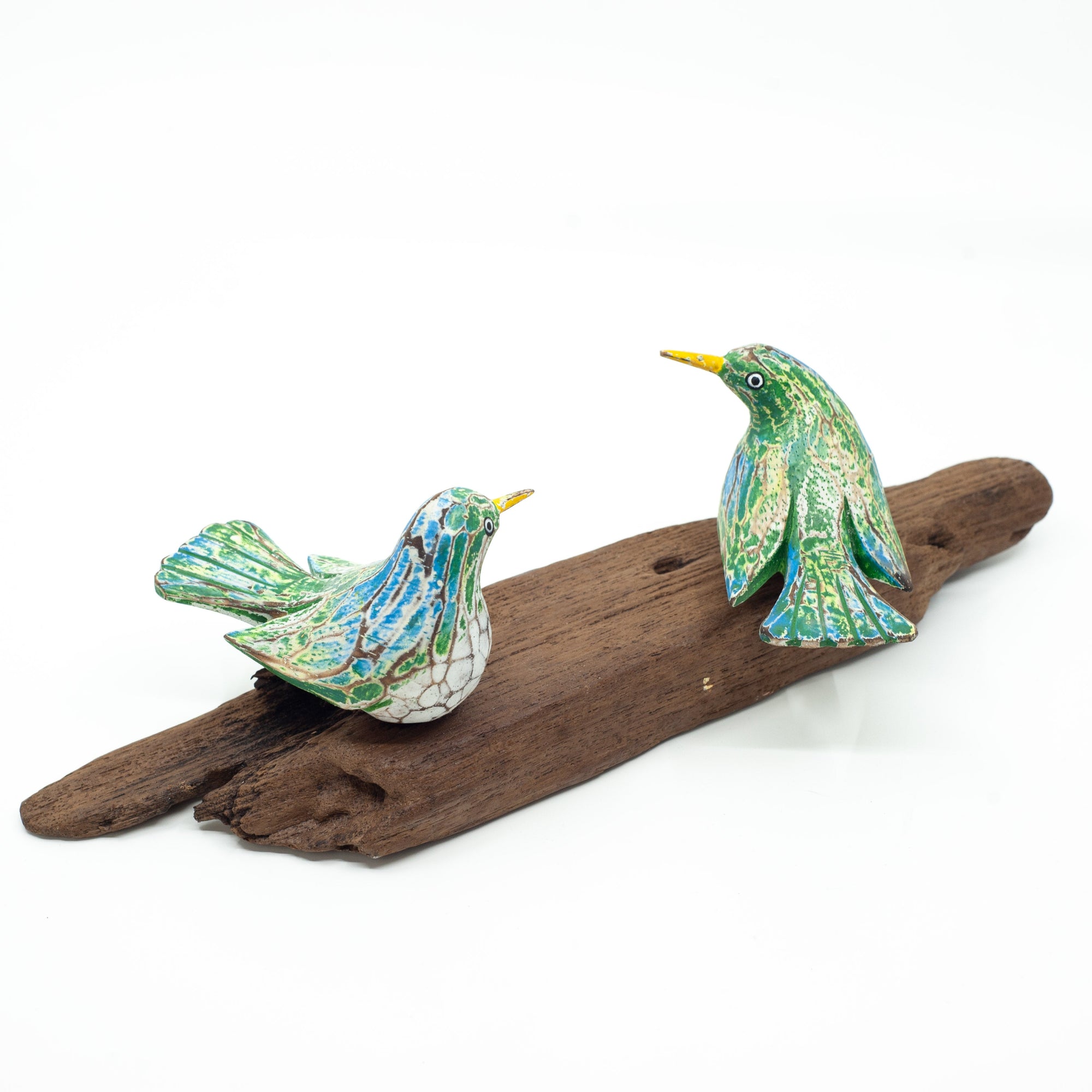 Small driftwood birds on white background on wooden base. 
