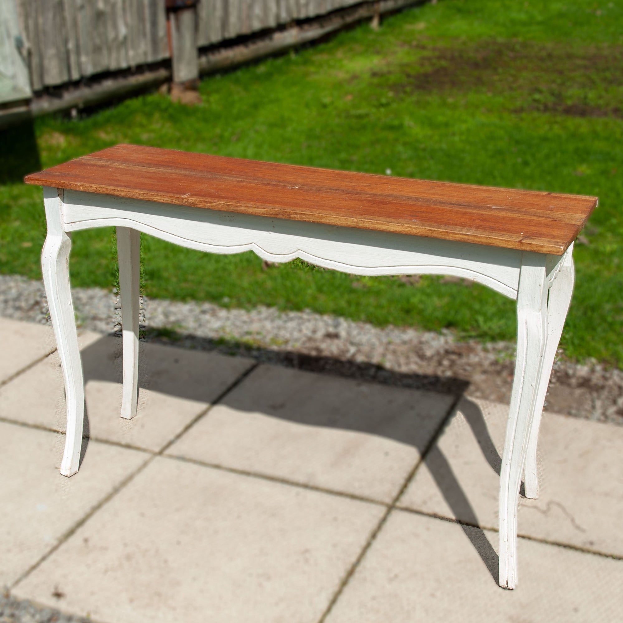 A rustic hallway table with wooden bike and white painted legs