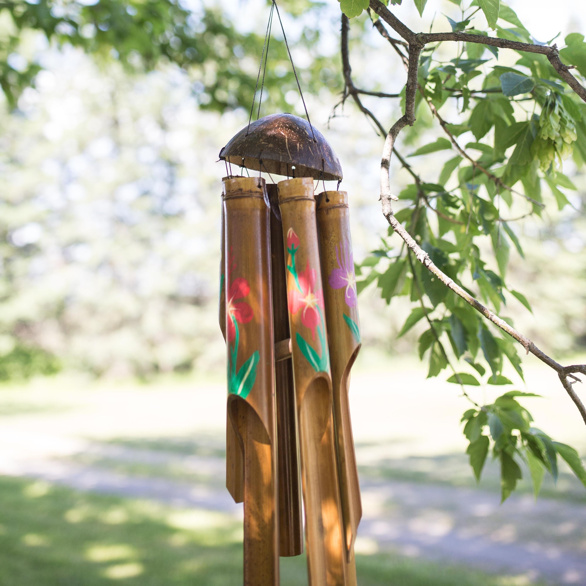Photo of painted bamboo windchimes hanging in a tree