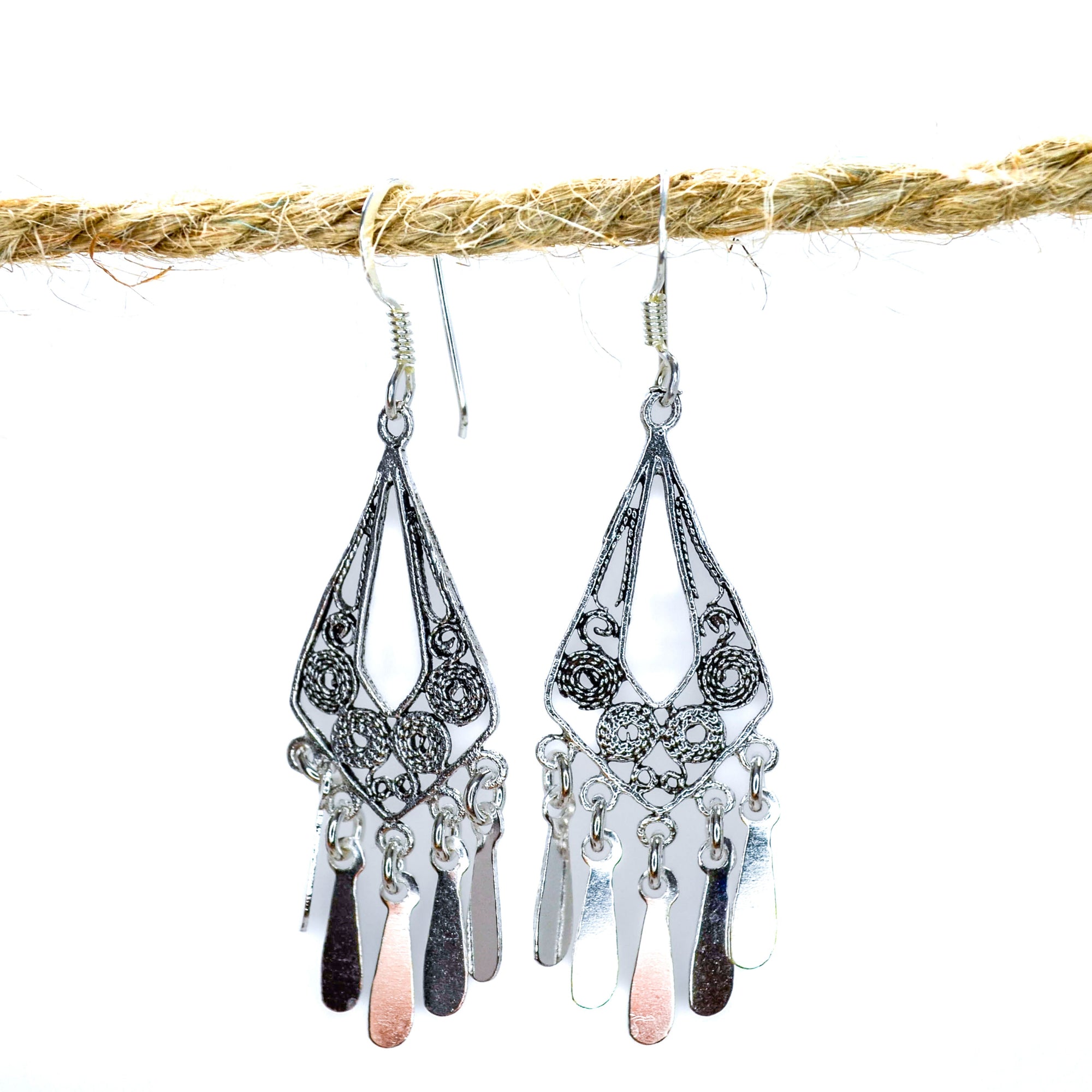 Triangular dangling earrings in silver with small swirl patterns inside 