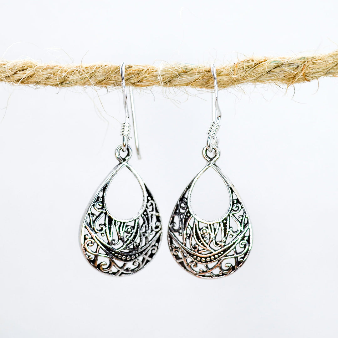 Teardrop shaped earrings in silver with intricate patterns inside