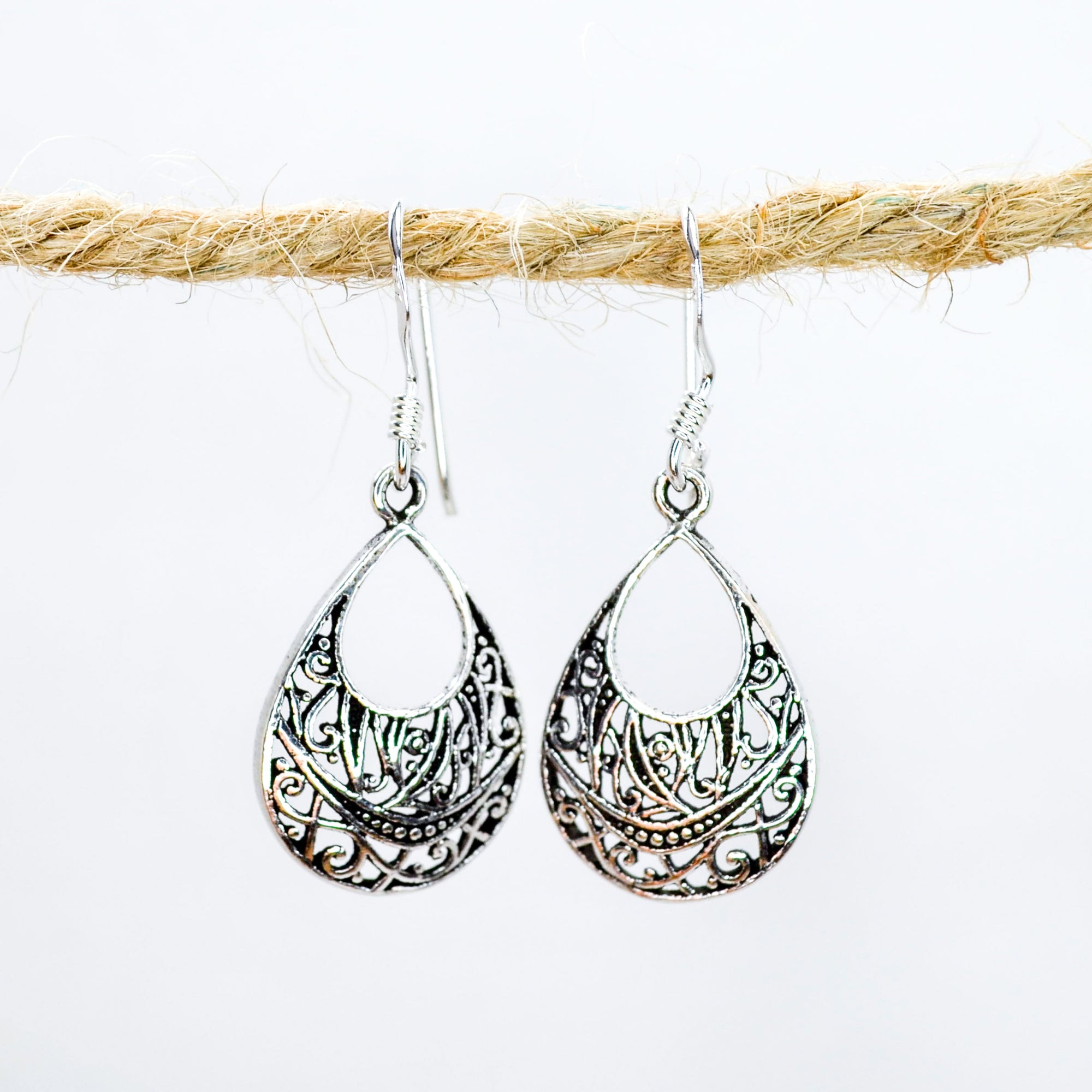 Teardrop shaped earrings in silver with intricate patterns inside