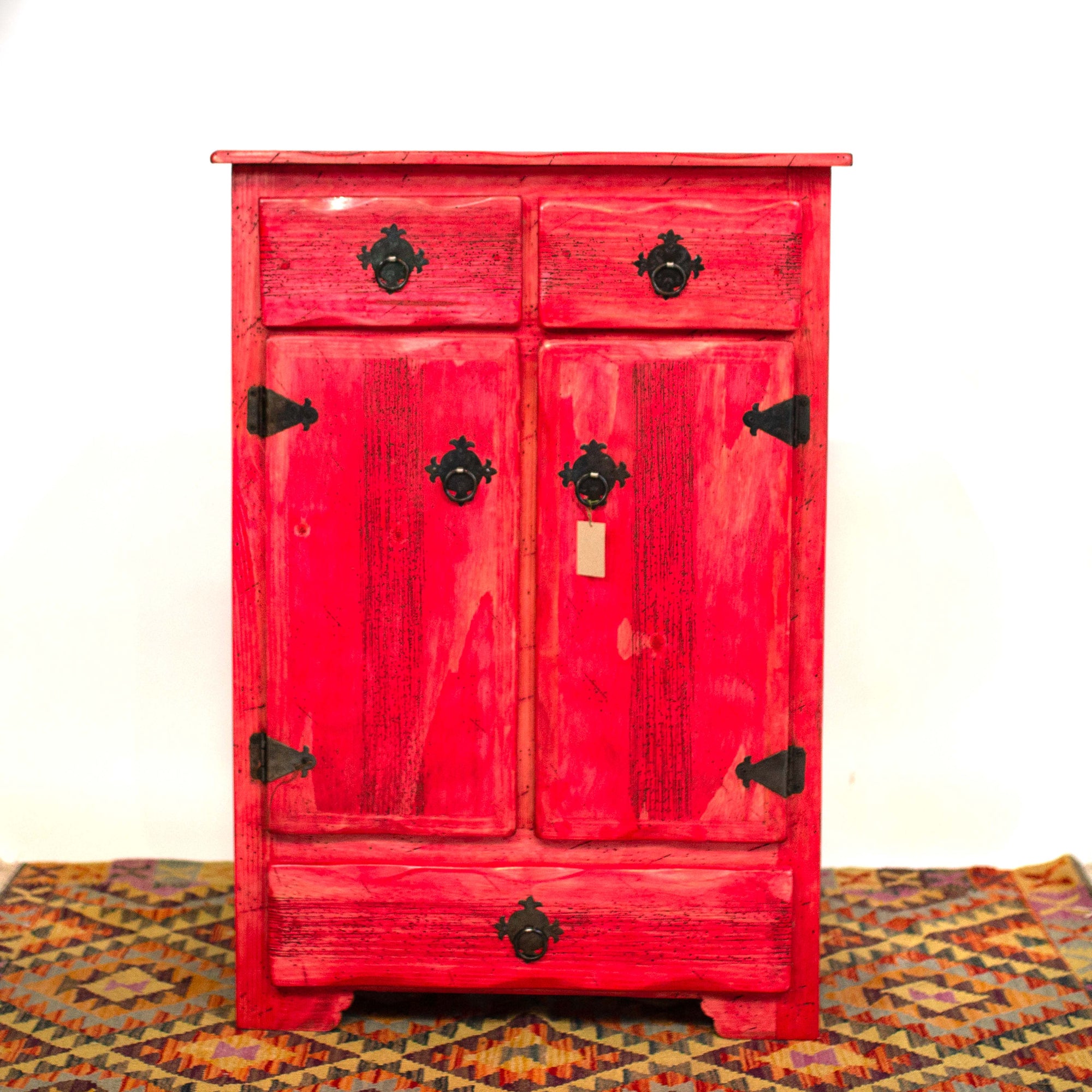 Photo of a tall Mexican cabinet with drawers and dressers in a vibrant red