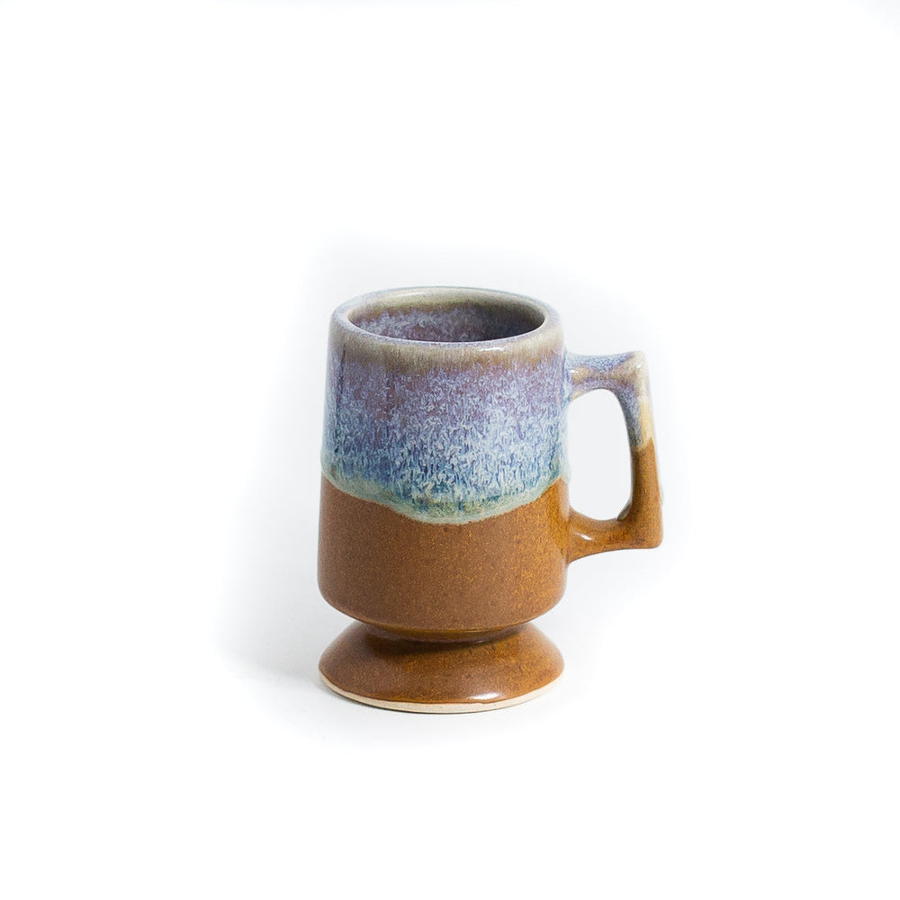 Sea and sand coloured coffee mugs stacked on white background