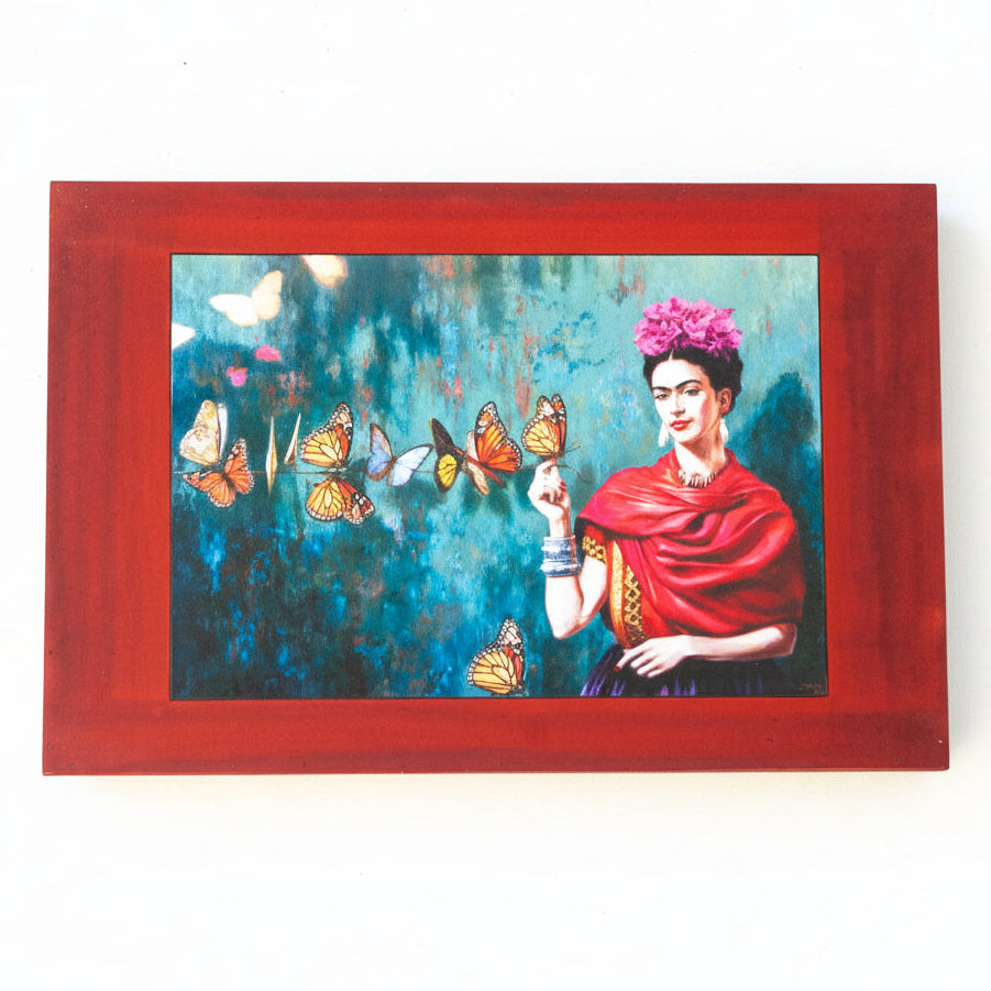 A portrait featuring Freida Kahlo with butterflies on red, wooden background
