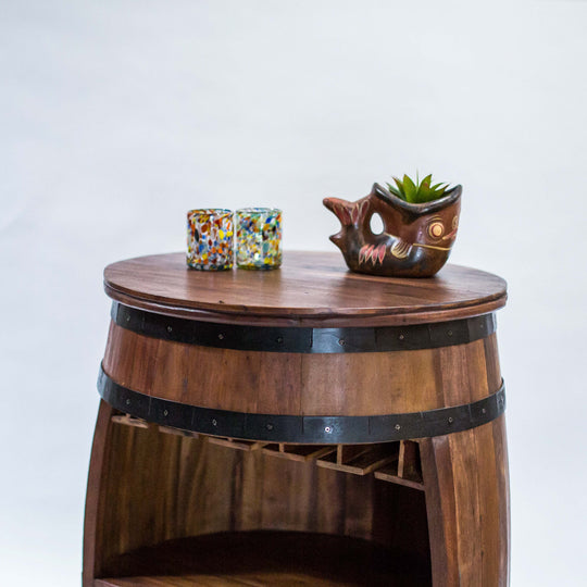 Photo of a teak wood barrel table with room for wine bottles and glasses.