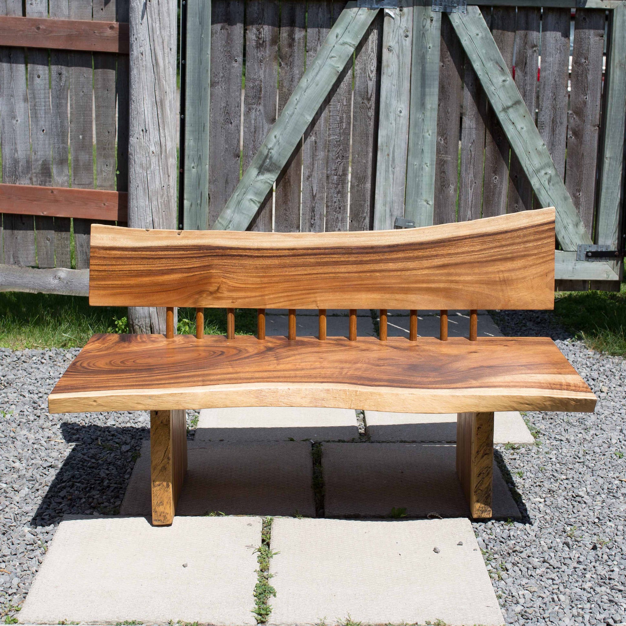 Photo of a sono wood large bench outdoors on a patio against a fence background